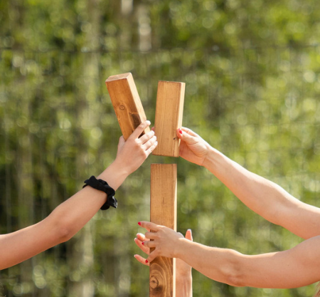 Peoples hands holding wooden blocks building together