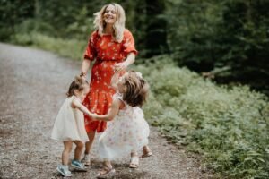 Mother and her children happily dancing outside together
